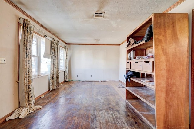 empty room featuring a textured ceiling, ornamental molding, and hardwood / wood-style flooring