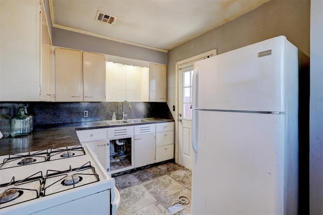 kitchen featuring decorative backsplash, sink, white cabinets, and white appliances