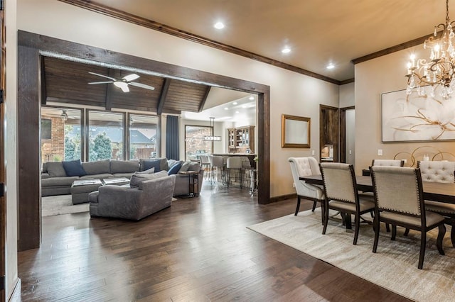 dining area featuring lofted ceiling with beams, ceiling fan with notable chandelier, baseboards, ornamental molding, and dark wood finished floors