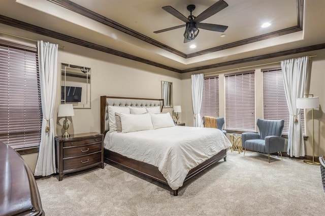 carpeted bedroom with ornamental molding, a raised ceiling, and ceiling fan