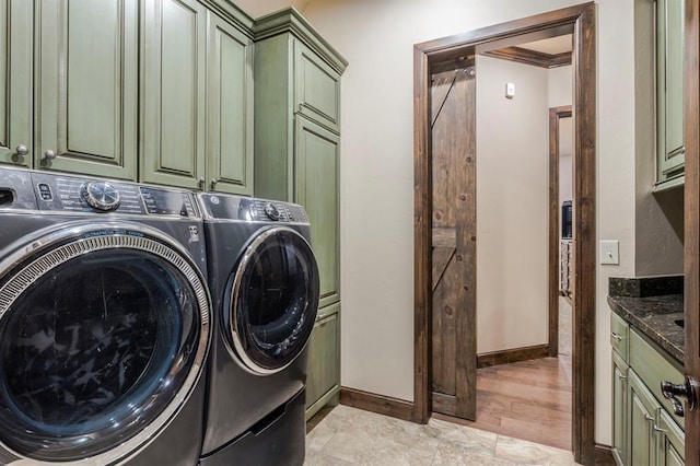 laundry room with cabinet space, crown molding, baseboards, and separate washer and dryer