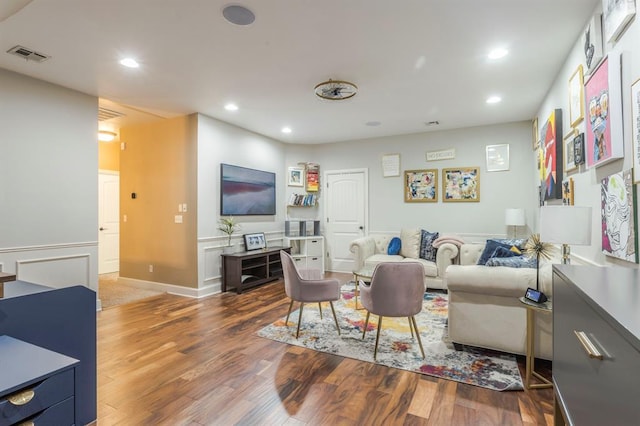 living room with recessed lighting, visible vents, baseboards, and wood finished floors