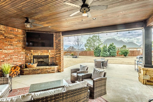 view of patio / terrace featuring an outdoor living space with a fireplace, a fenced backyard, ceiling fan, and outdoor dining space