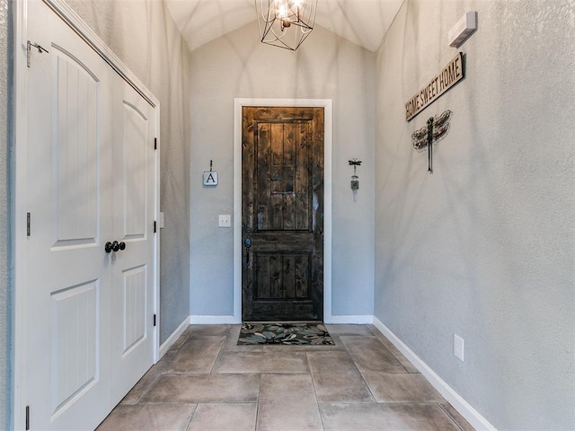 foyer entrance with a chandelier and vaulted ceiling