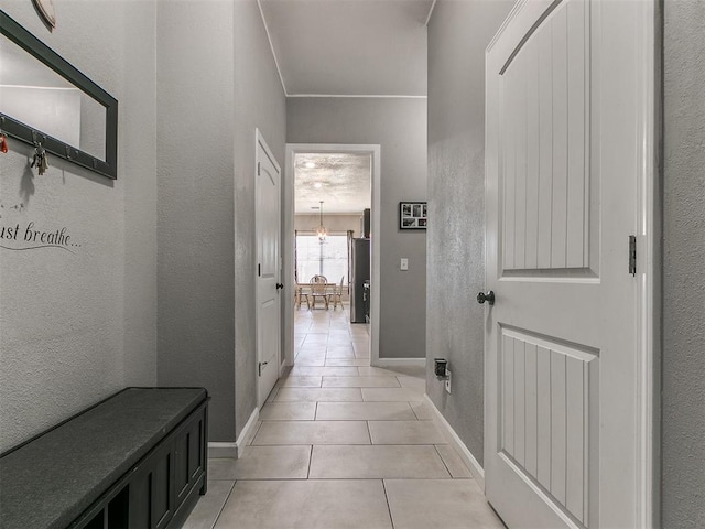 hall featuring a notable chandelier and light tile patterned flooring