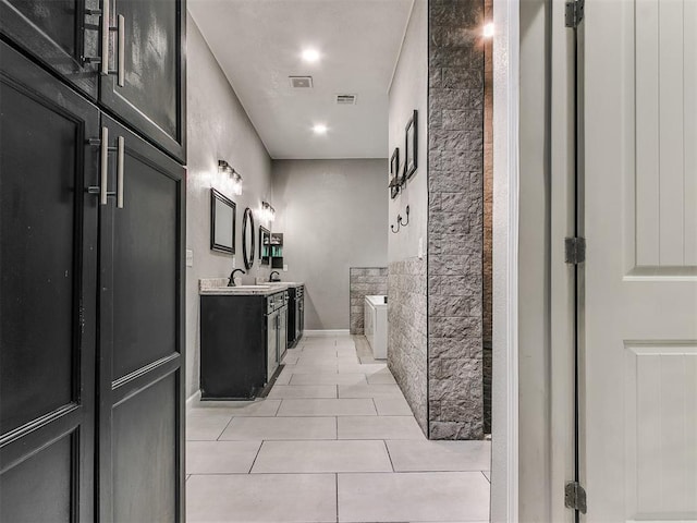 bathroom with vanity, a bathing tub, and tile patterned flooring