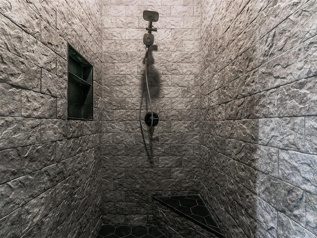 interior details featuring tiled shower