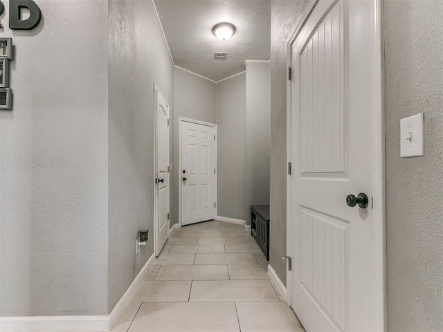 interior space featuring light tile patterned floors and crown molding