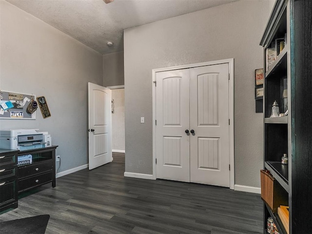 bedroom with a textured ceiling, a closet, and dark hardwood / wood-style flooring