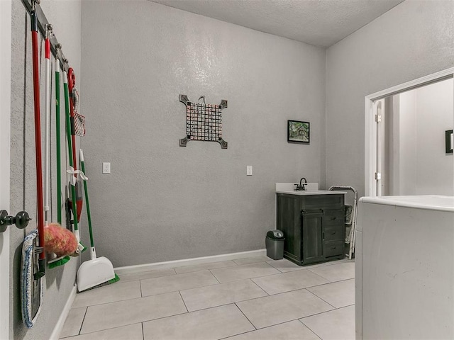 bathroom with a textured ceiling, tile patterned floors, and vanity