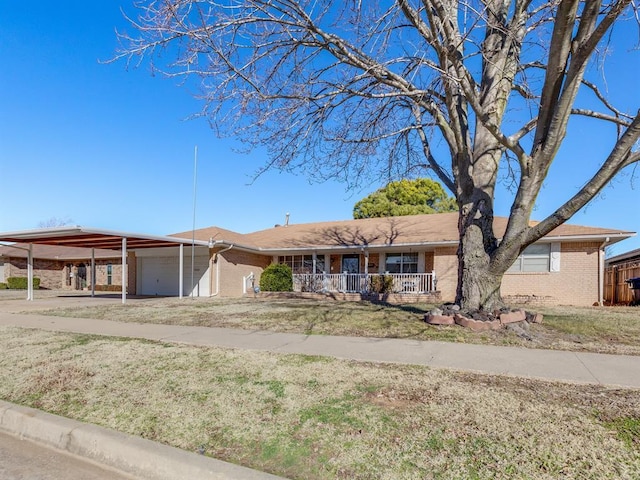 view of front of property with covered porch, a garage, a carport, and a front lawn