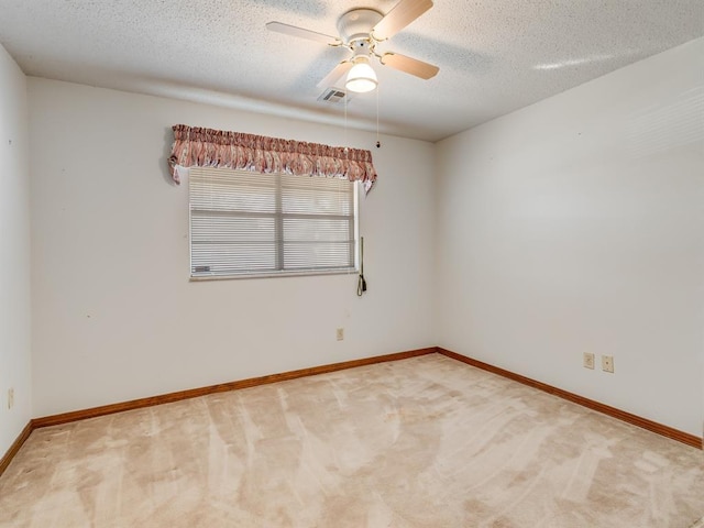 carpeted empty room featuring ceiling fan and a textured ceiling