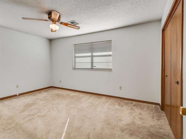 unfurnished bedroom featuring a textured ceiling, ceiling fan, and carpet