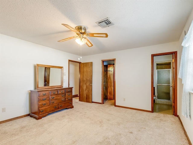 carpeted bedroom featuring ceiling fan, connected bathroom, and a textured ceiling