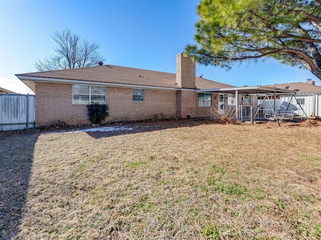 rear view of property featuring a yard