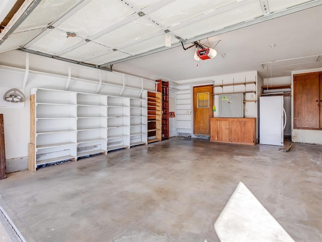 garage with a garage door opener and white fridge