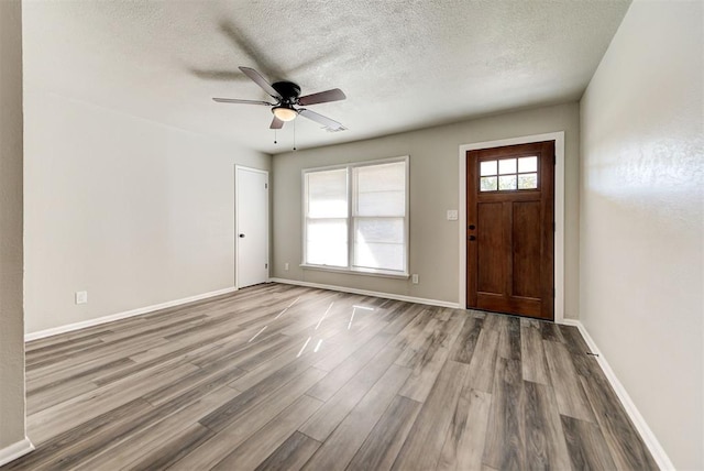 entryway featuring ceiling fan, wood-type flooring, and a textured ceiling