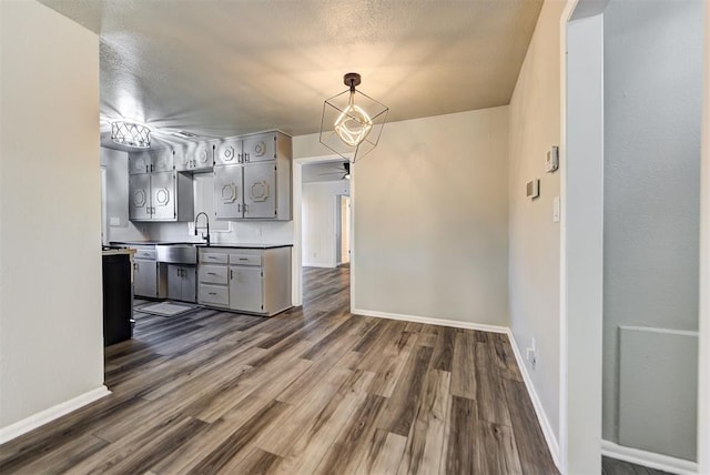 kitchen with ceiling fan, sink, dark wood-type flooring, gray cabinetry, and a textured ceiling