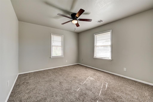 carpeted spare room featuring ceiling fan