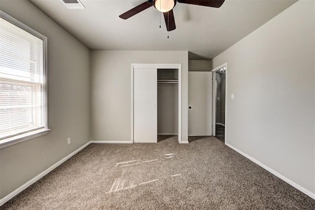 unfurnished bedroom featuring ceiling fan, carpet floors, and multiple windows