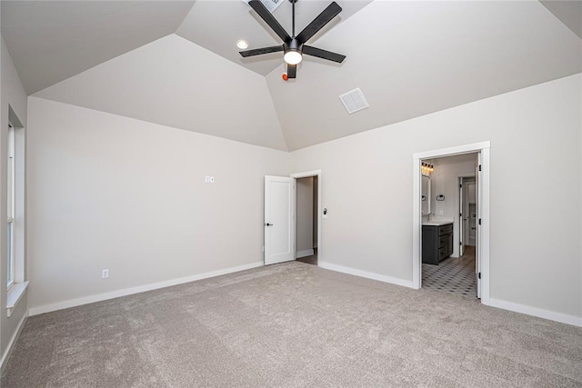 unfurnished bedroom with ceiling fan, light colored carpet, ensuite bathroom, and vaulted ceiling