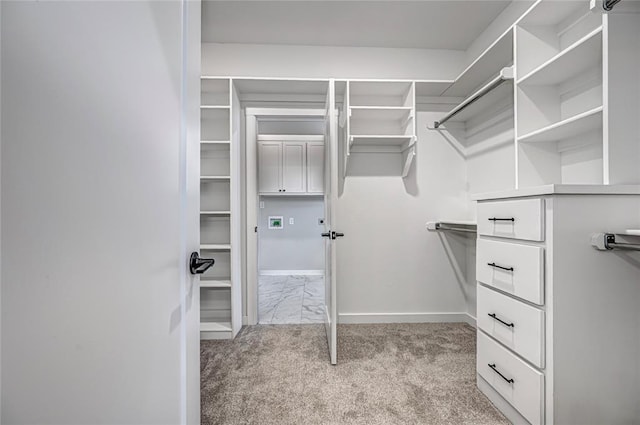 walk in closet featuring light carpet