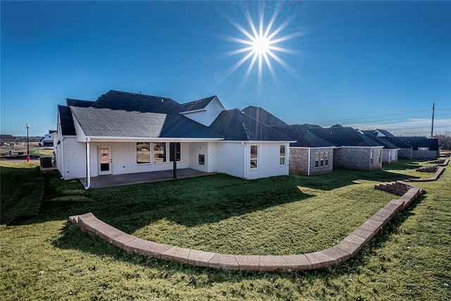 rear view of house featuring central AC, a yard, and a patio