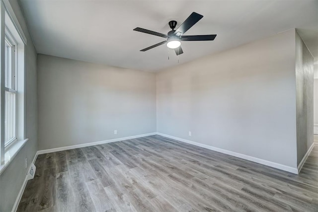 unfurnished room featuring a healthy amount of sunlight, ceiling fan, and light hardwood / wood-style flooring