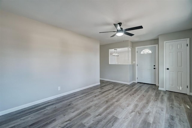 unfurnished room with ceiling fan with notable chandelier and light hardwood / wood-style floors