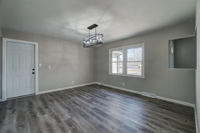 unfurnished dining area featuring an inviting chandelier and dark hardwood / wood-style floors