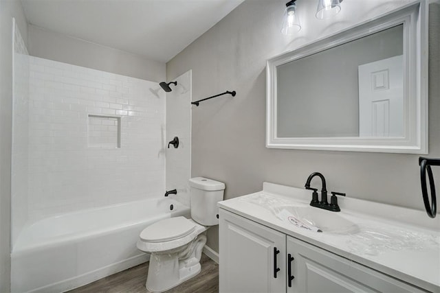 full bathroom featuring vanity, tiled shower / bath combo, wood-type flooring, and toilet