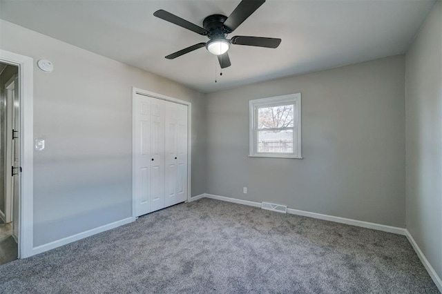 unfurnished bedroom featuring light carpet, ceiling fan, and a closet