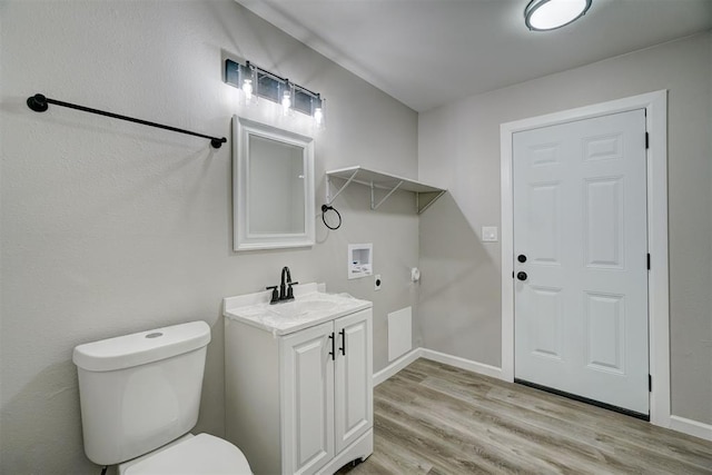 bathroom with hardwood / wood-style flooring, vanity, and toilet