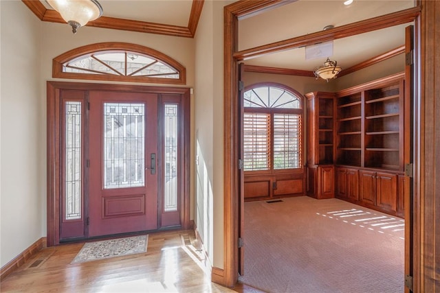 carpeted foyer featuring ornamental molding