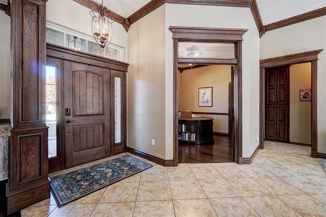 tiled foyer entrance with crown molding and a chandelier