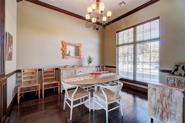 dining room with crown molding, dark hardwood / wood-style flooring, and a chandelier