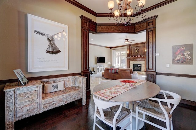 dining room featuring ornamental molding, dark hardwood / wood-style flooring, and a tile fireplace