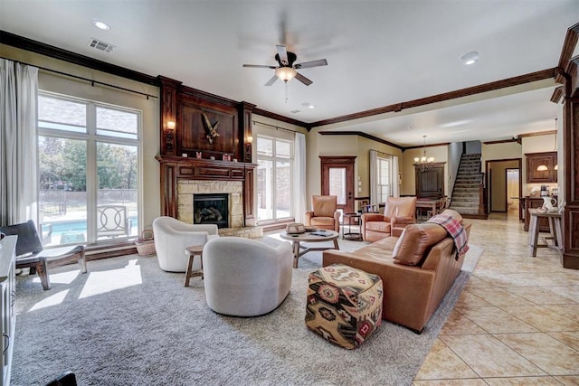 tiled living room with crown molding, ceiling fan with notable chandelier, and a fireplace