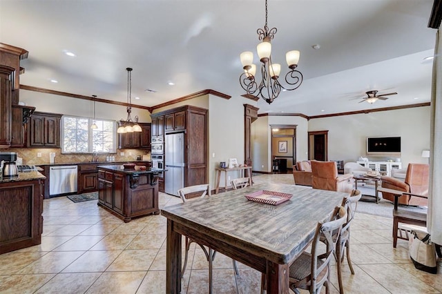 tiled dining room with ornamental molding, sink, ceiling fan with notable chandelier, and decorative columns