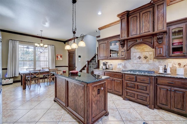 kitchen featuring decorative light fixtures, light tile patterned floors, dark stone countertops, a kitchen island, and decorative backsplash