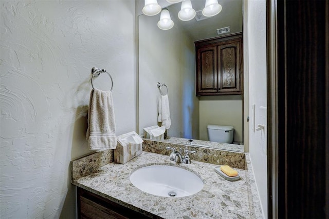 bathroom featuring vanity and toilet