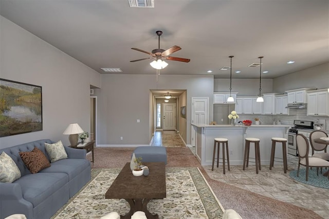 living room featuring light tile patterned floors and ceiling fan