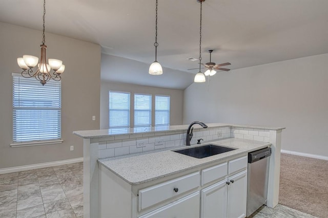 kitchen featuring stainless steel dishwasher, sink, decorative light fixtures, white cabinets, and light stone counters