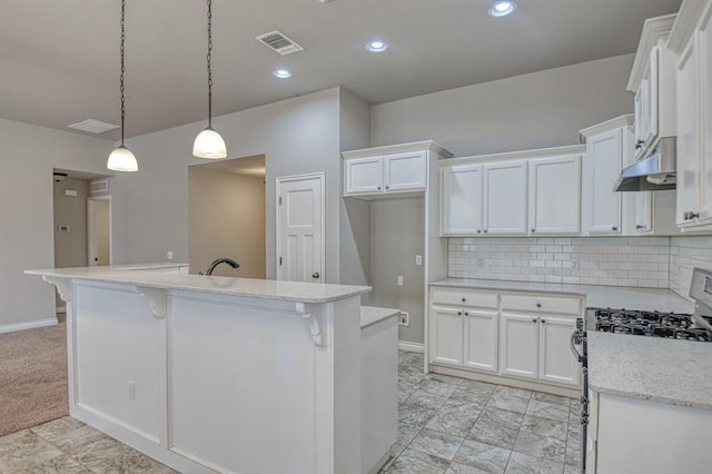 kitchen with white cabinetry, hanging light fixtures, a center island with sink, and stainless steel gas range oven