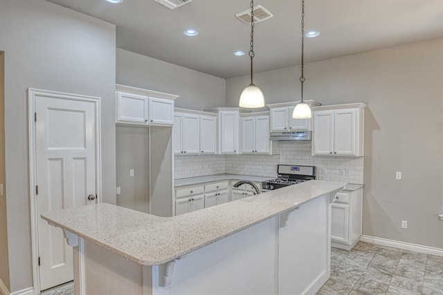 kitchen featuring light stone countertops, a kitchen island, white cabinetry, backsplash, and stainless steel range with gas stovetop