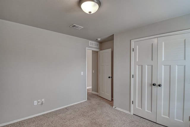 unfurnished bedroom with a closet and light colored carpet