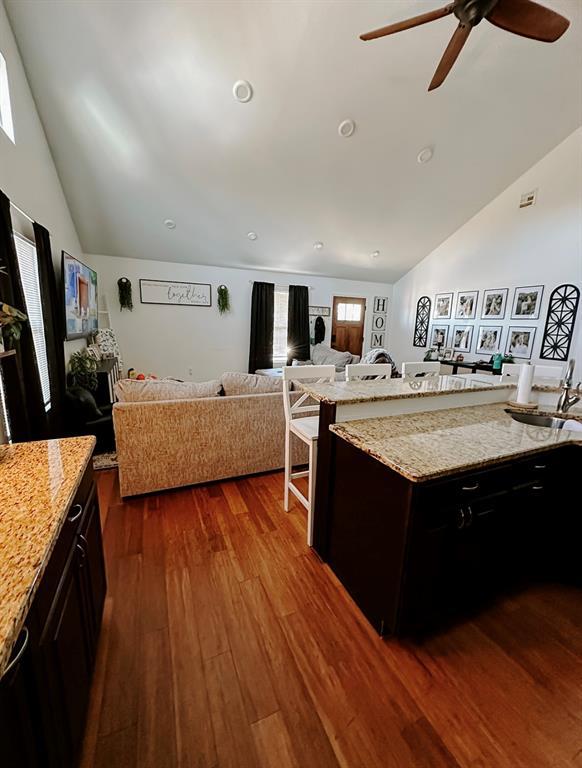 kitchen with ceiling fan, dark hardwood / wood-style flooring, sink, and light stone countertops