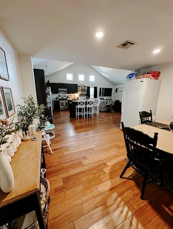 dining space featuring lofted ceiling and hardwood / wood-style flooring