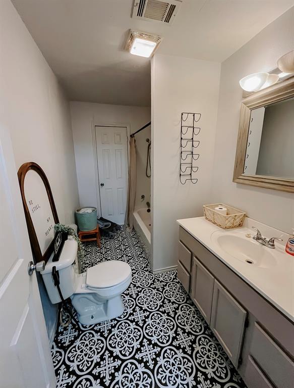 full bathroom featuring toilet, vanity, tile patterned floors, and shower / tub combo with curtain