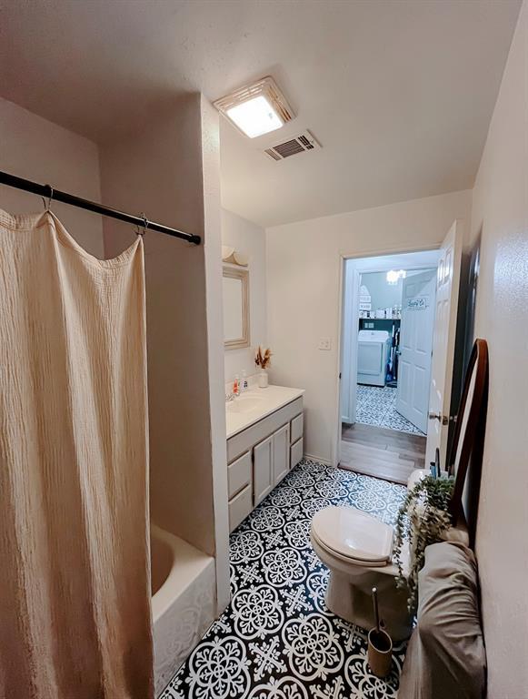 full bathroom featuring vanity, toilet, washer / clothes dryer, and bathtub / shower combination